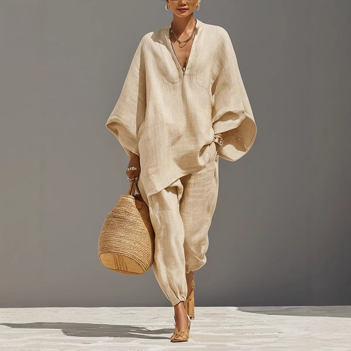 A woman wearing a casual beige two-piece shirt and jogger set with a straw bag.
