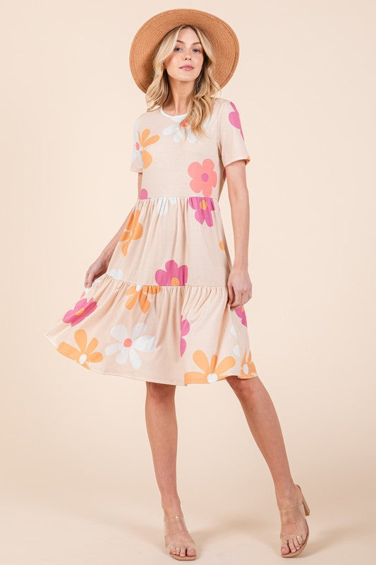 A feminine floral print tiered mini dress with short sleeves and a round neck