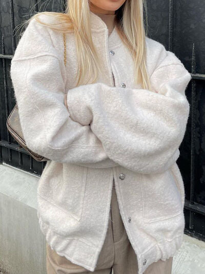 Casual drop shoulder snap down jacket with pockets available in cream, grey, and olive green.