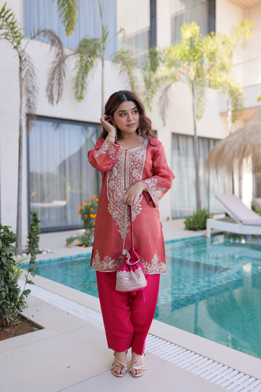 A maroon viscose kurta pant set with intricate sequins, coding zari embroidery, and a matching Batwa bag.