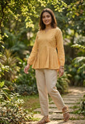 Model wearing a yellow linen cotton co-ord set with pleated top and matching pants