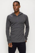 Men wearing a long sleeve charcoal grey henley hooded top with button placket