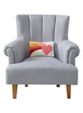 Small rectangular throw pillow with a vibrant, hooked wool design showing a heart and rainbow motif, resting on a gray upholstered chair.