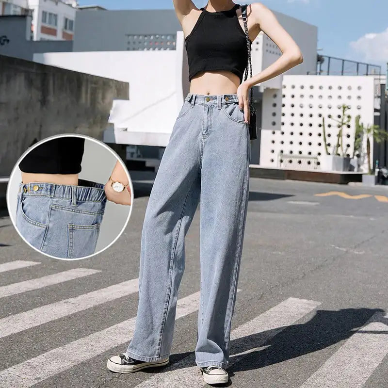 Model wearing loose-fitting light wash wide leg jeans with an elastic waistband and a black tank top.