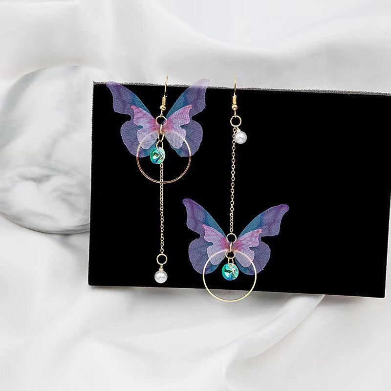 A pair of vibrant purple asymmetric butterfly earrings featuring a retro bow knot design.