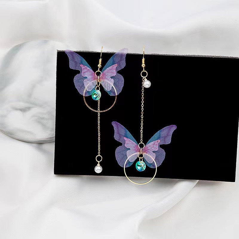 A pair of vibrant purple asymmetric butterfly earrings featuring a retro bow knot design.