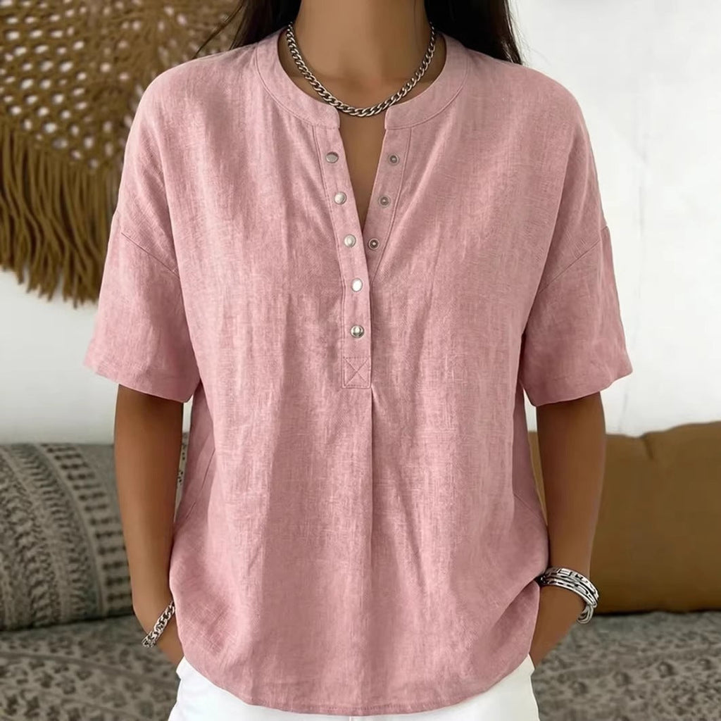 A woman wearing a loose-fit short-sleeve button-front henley pullover top
