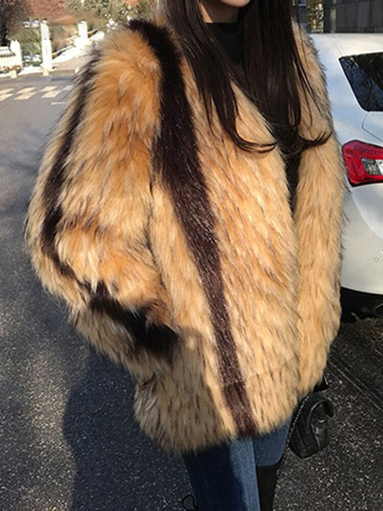 Harajuku style women's faux fur coat with brown and cream vertical stripes worn over black top and jeans