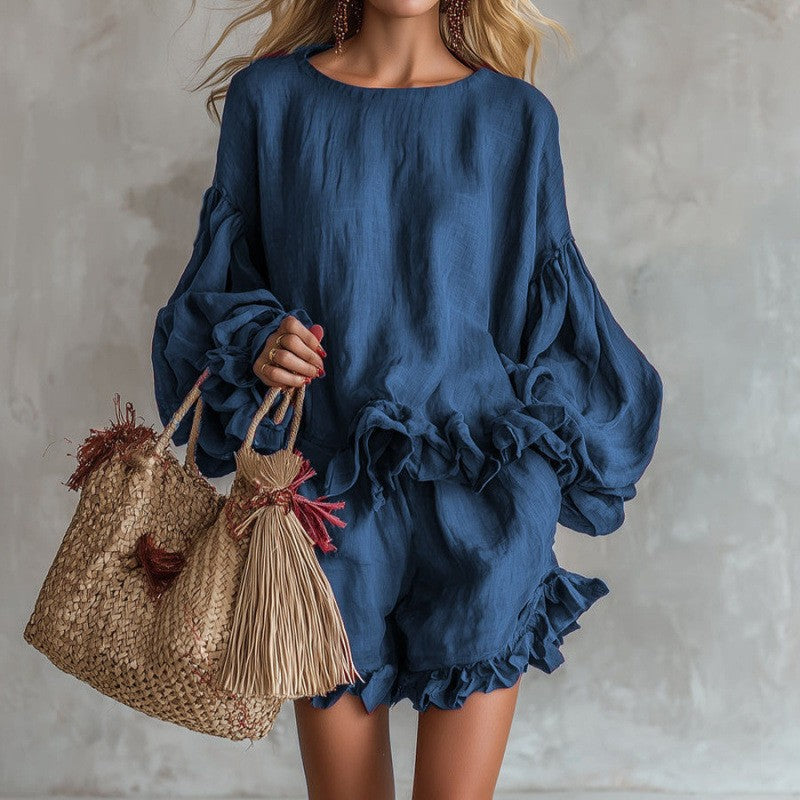 Model wearing a blue two-piece set with a lantern sleeve top and ruffled shorts.