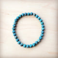 Natural American Turquoise 6mm beaded stretch bracelet on a light wood background