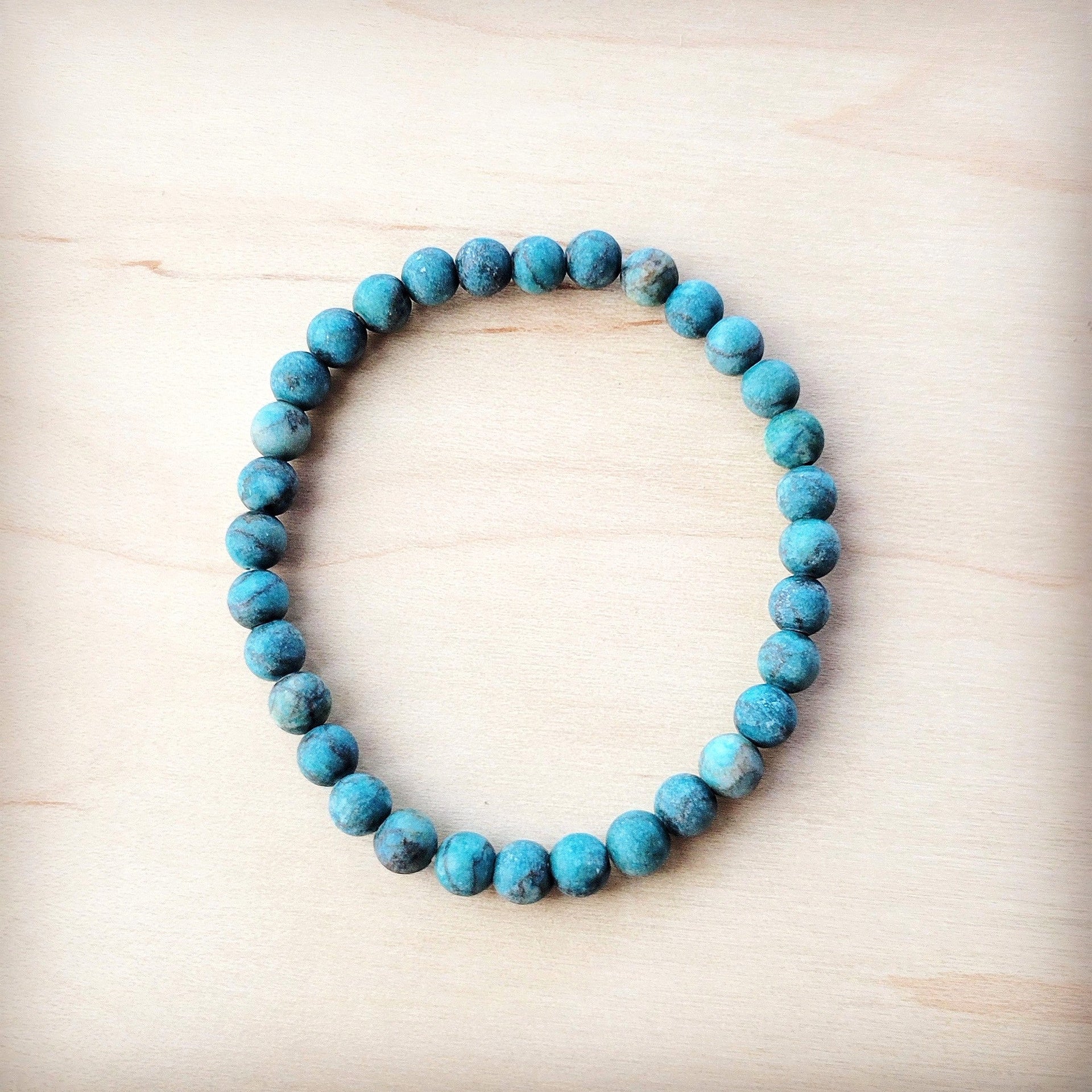 Natural American Turquoise 6mm beaded stretch bracelet on a light wood background