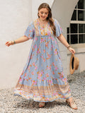 Bohemian floral maxi dress with flutter sleeves and a ruched waist tie in light blue, pink, and orange.
