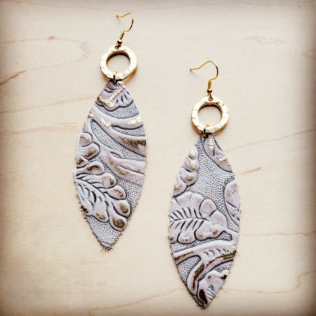 Genuine leather oval earrings with gold-tone hammered metal rings and Gilded Cowboy patterned leather drops.