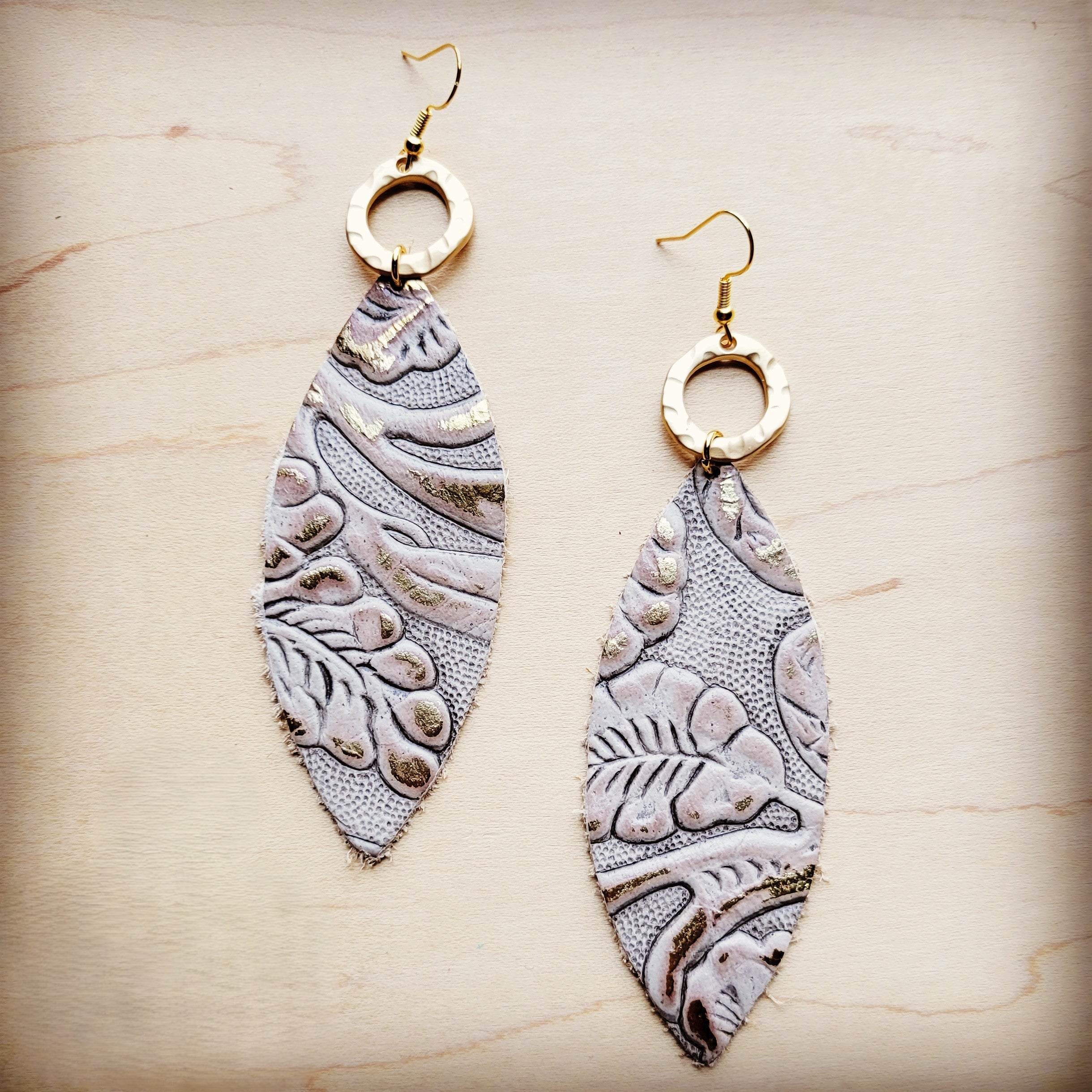 Genuine leather oval earrings with gold-tone hammered metal rings and Gilded Cowboy patterned leather drops.