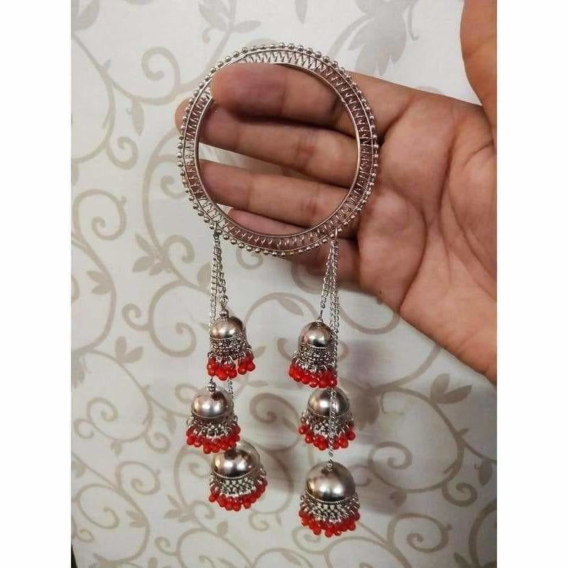 Silver-tone bangle featuring red pearls and a three-step dangling jhumka design