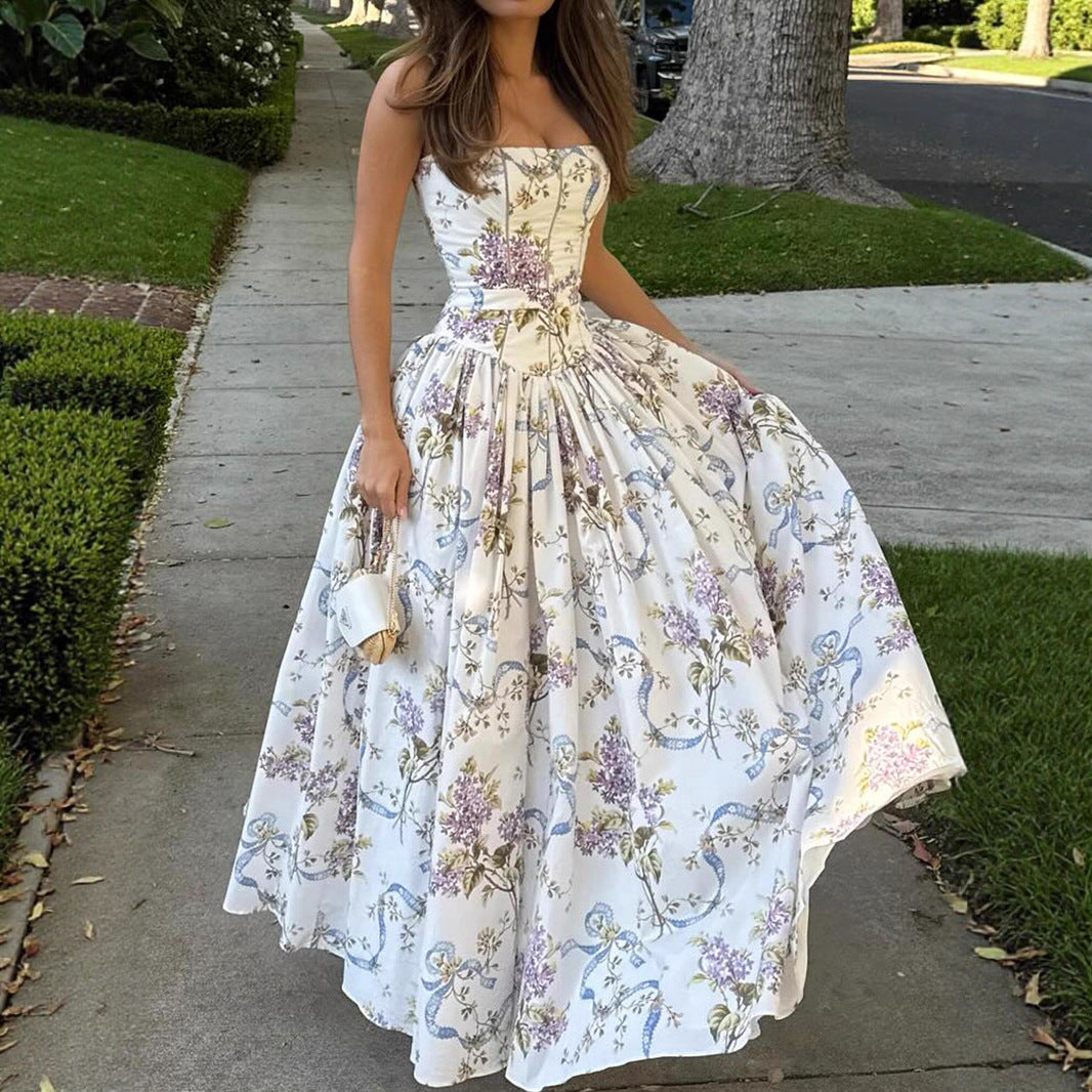Woman wearing a floral printed strapless backless maxi dress in white, purple, and blue.