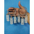 Silver-tone bangle featuring hanging jhumkas and white pearl chains for traditional wear.