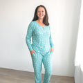Woman wearing a matching teal moon and stars pattern ribbed long-sleeve pajama set