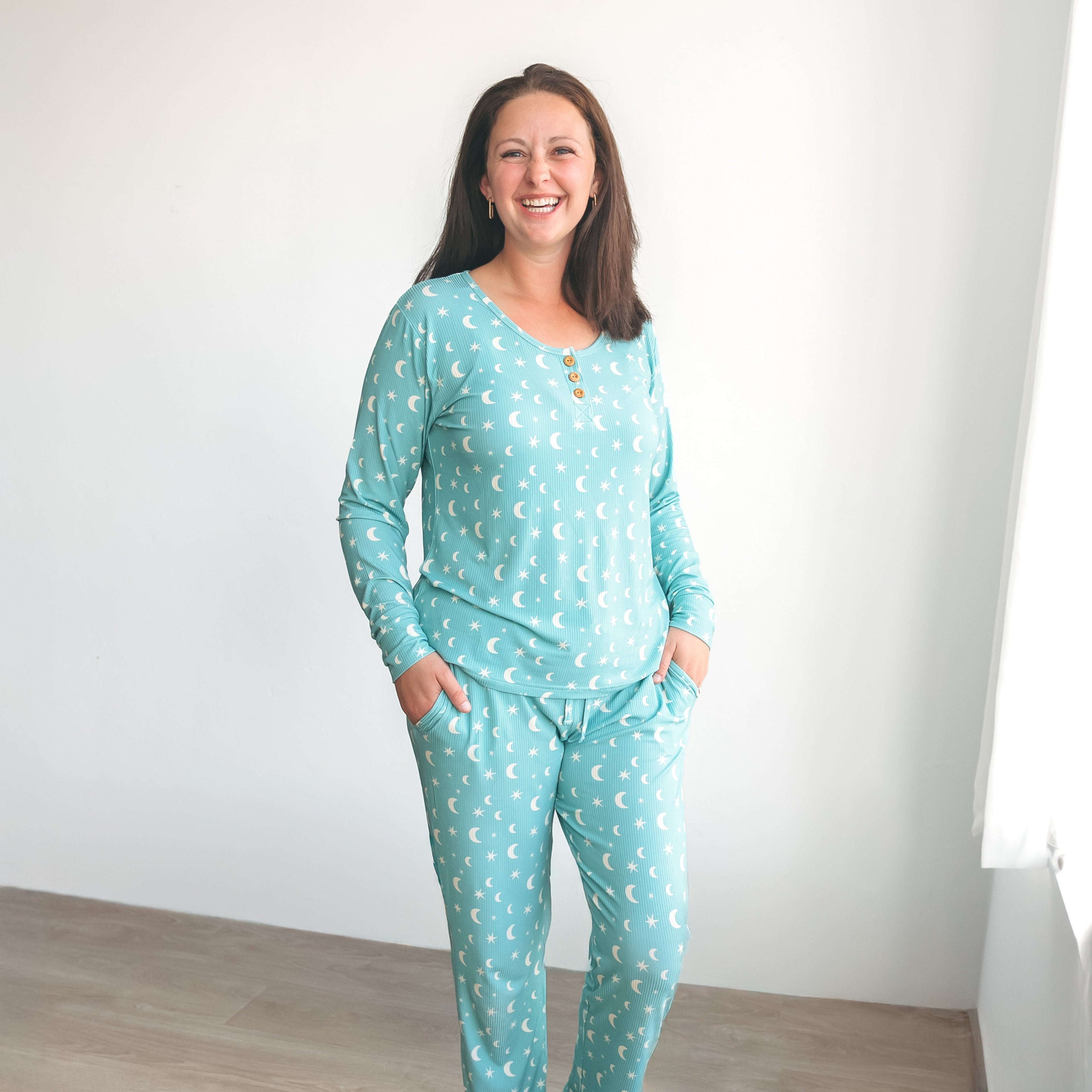 Woman wearing a matching teal moon and stars pattern ribbed long-sleeve pajama set