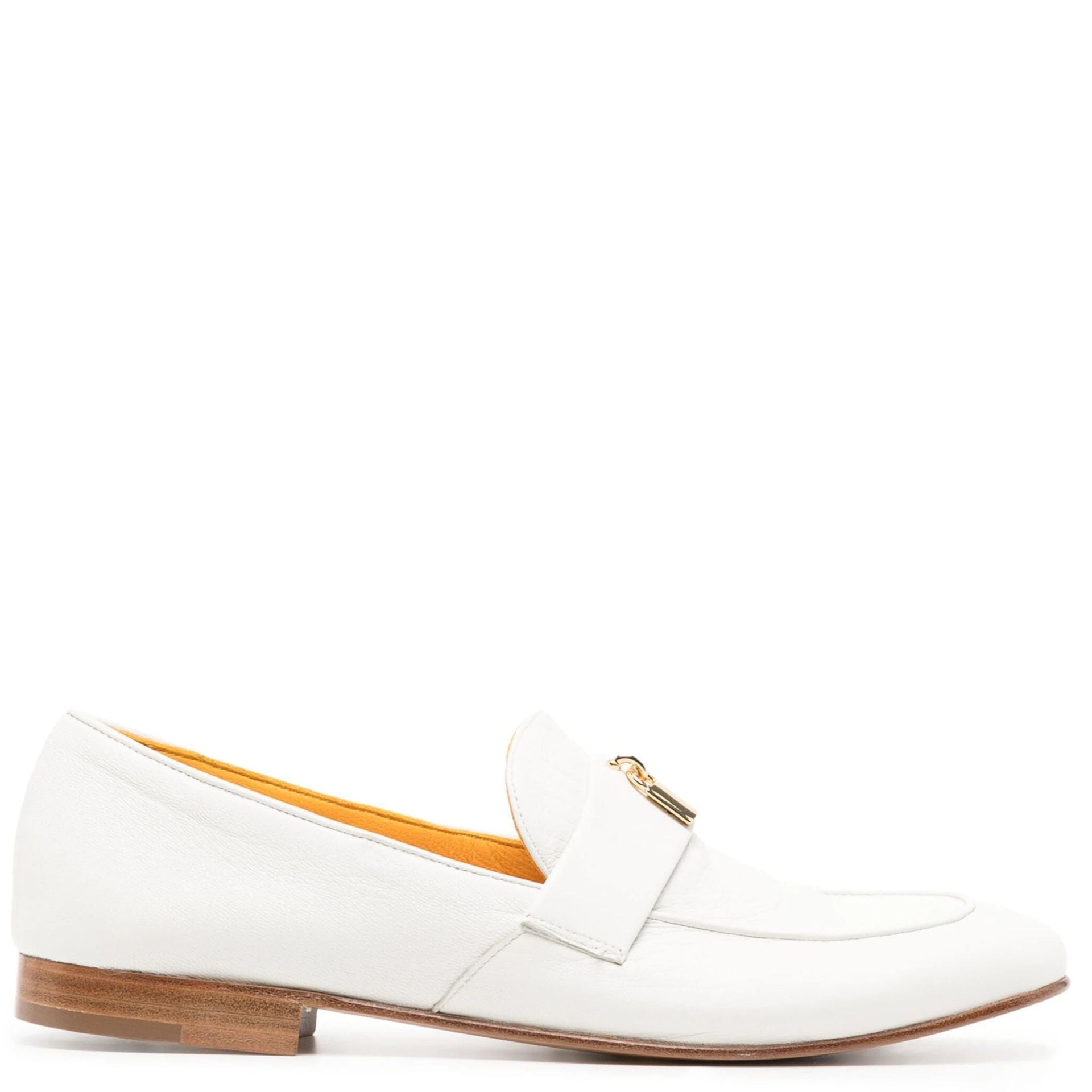 Side profile of a white leather flat loafer with gold lock hardware on a white background