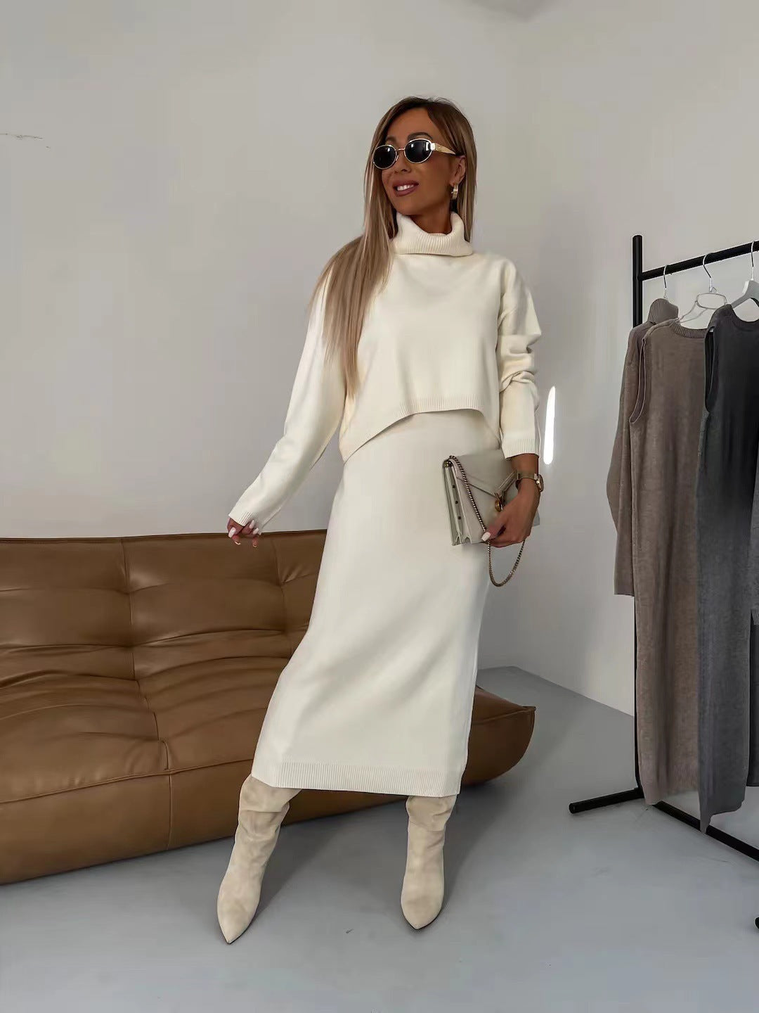 Woman wearing a two-piece white knit turtleneck sweater and sleeveless long dress set.