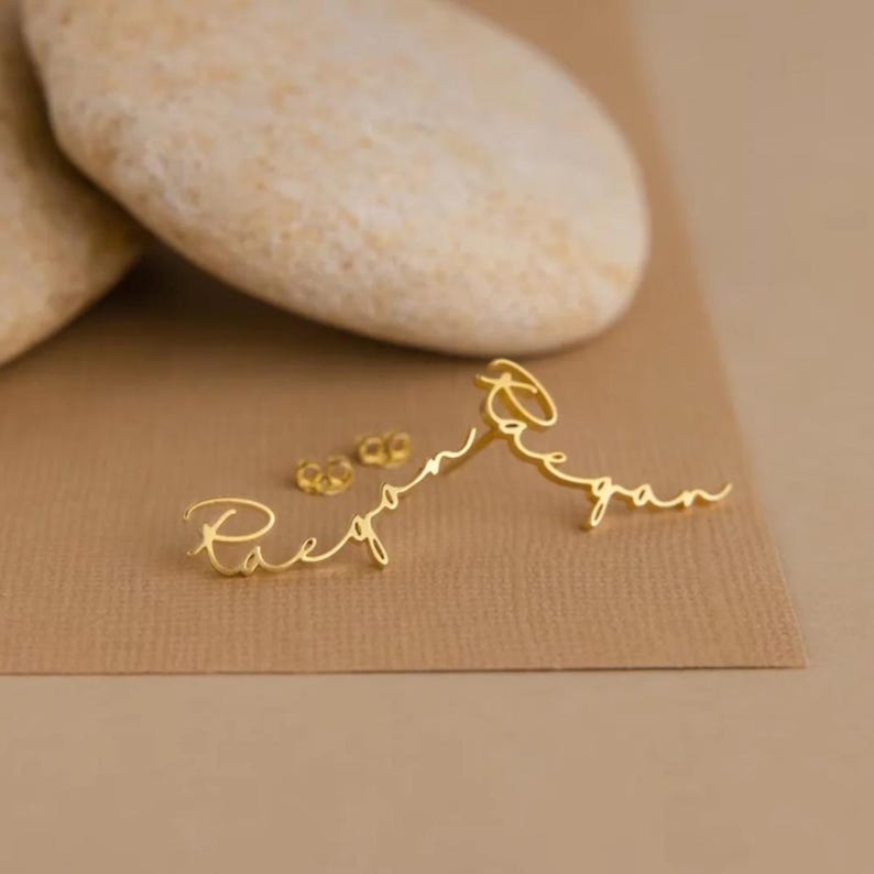 Custom gold-tone stud earrings featuring elegant script name personalization