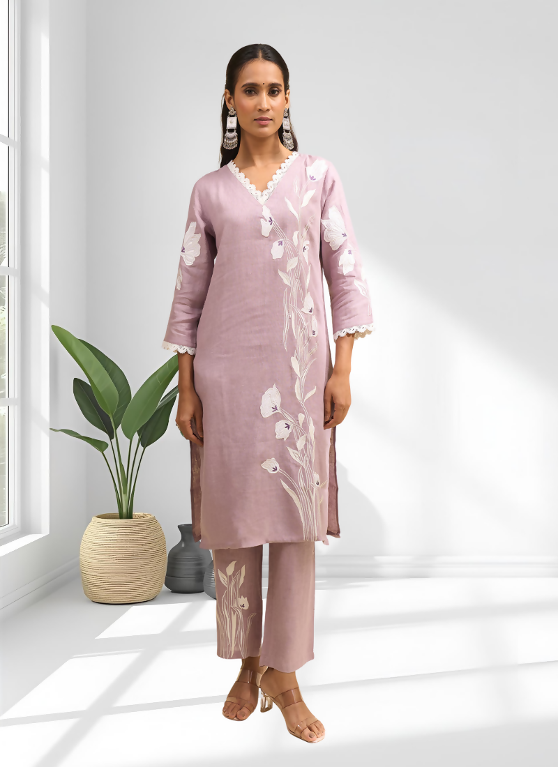 Woman wearing a pink linen embroidered long kurta set with matching trousers