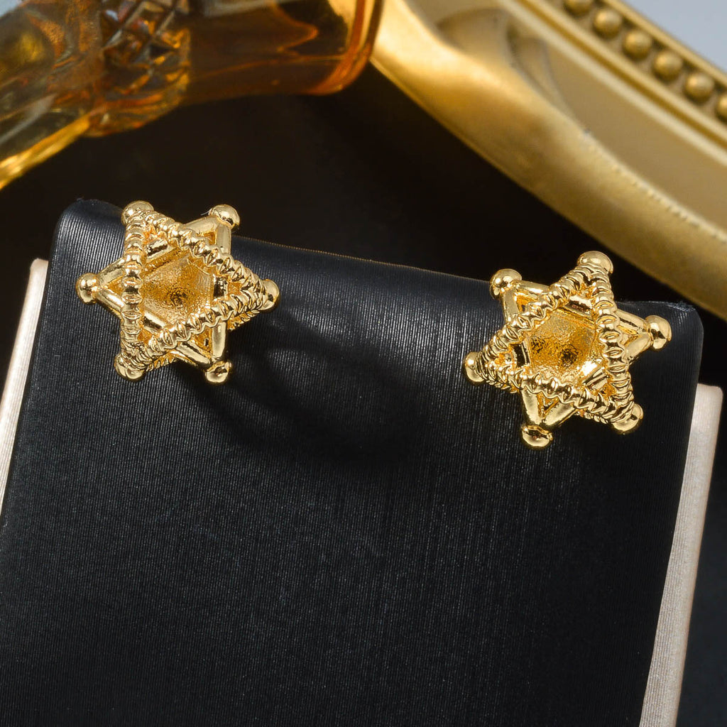 A pair of gold-plated minimalist hollow star stud earrings on a white background.