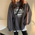 Woman wearing a loose oversized Brooklyn graphic crew neck sweatshirt in wine red