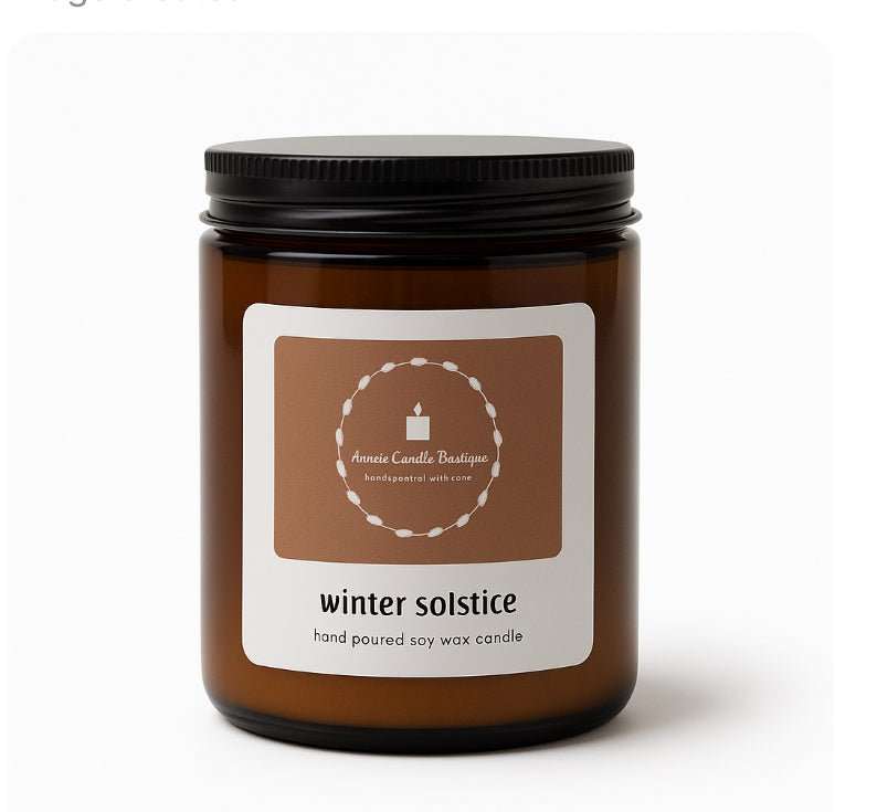 Amber glass jar containing a Winter Solstice hand-poured soy wax candle with a minimalist cream and brown label.