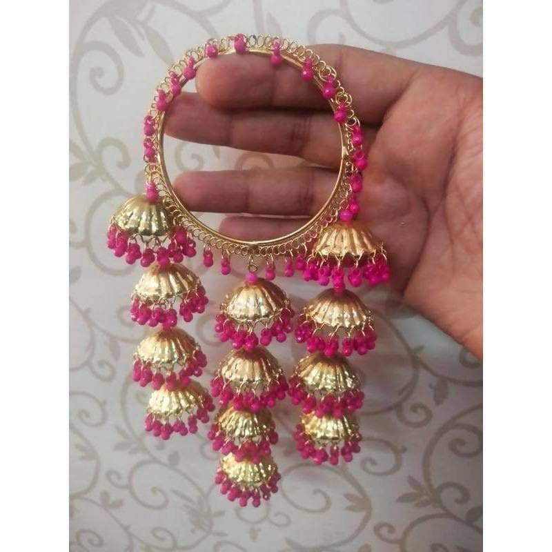 Pink pearl latkan bangle with gold-tone jhumka accents on a white background.