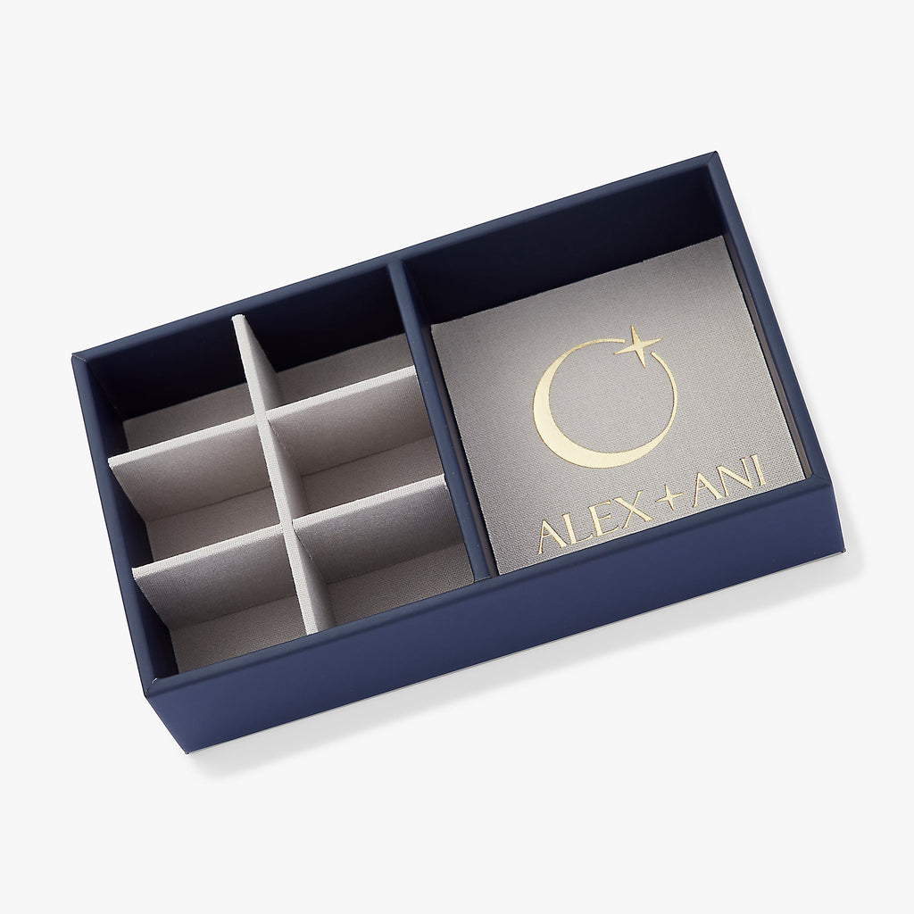 A luxe suede jewelry storage tray with signature logo and internal compartments for necklaces, bracelets, and earrings.