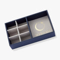 A luxe suede jewelry storage tray with signature logo and internal compartments for necklaces, bracelets, and earrings.