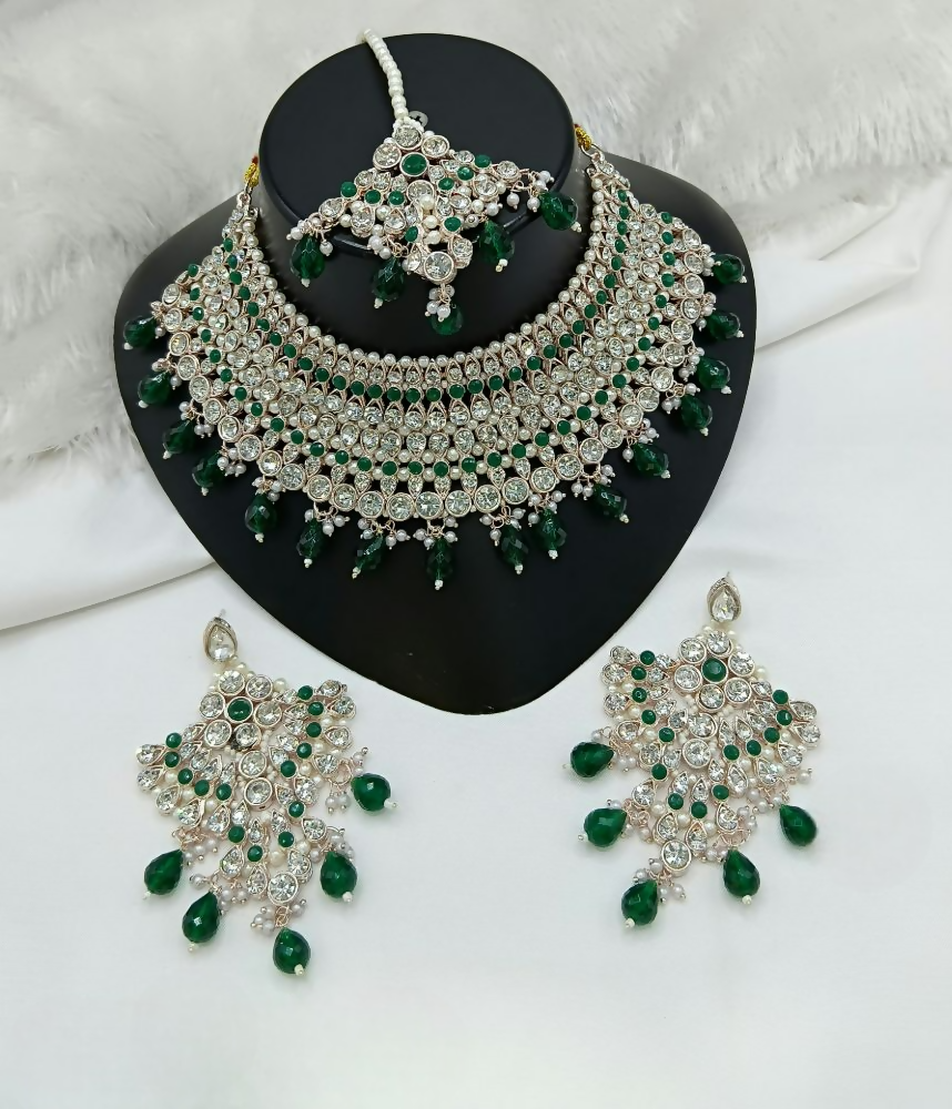 Green stone work necklace and earring set on a neutral background