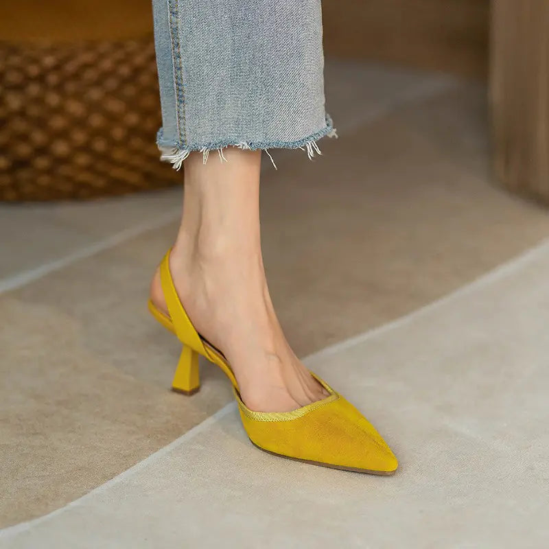 Close up of yellow pointed toe slingback heels worn with cropped jeans.