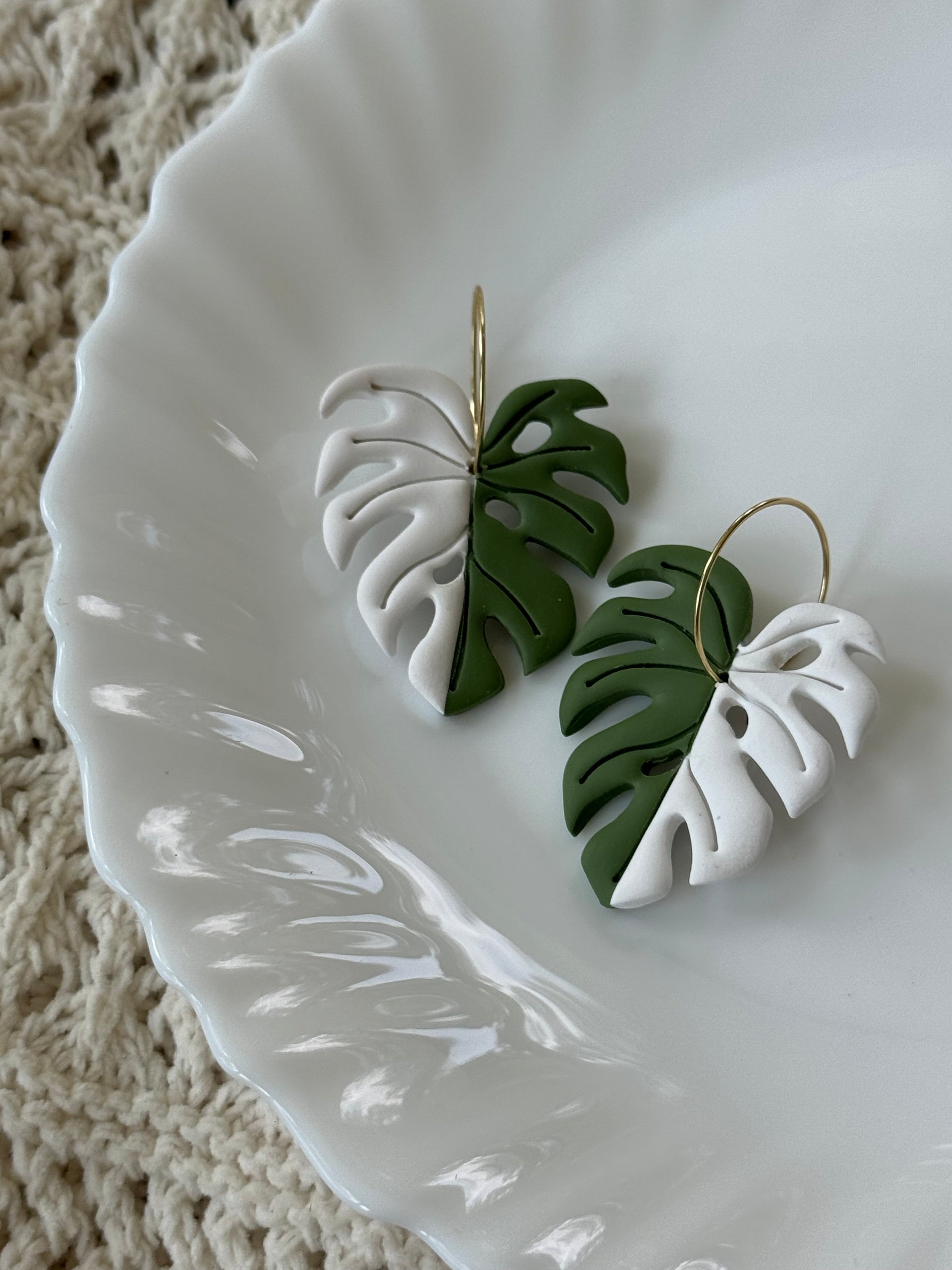Handmade Variegated Monstera polymer clay leaf earrings with gold hardware.