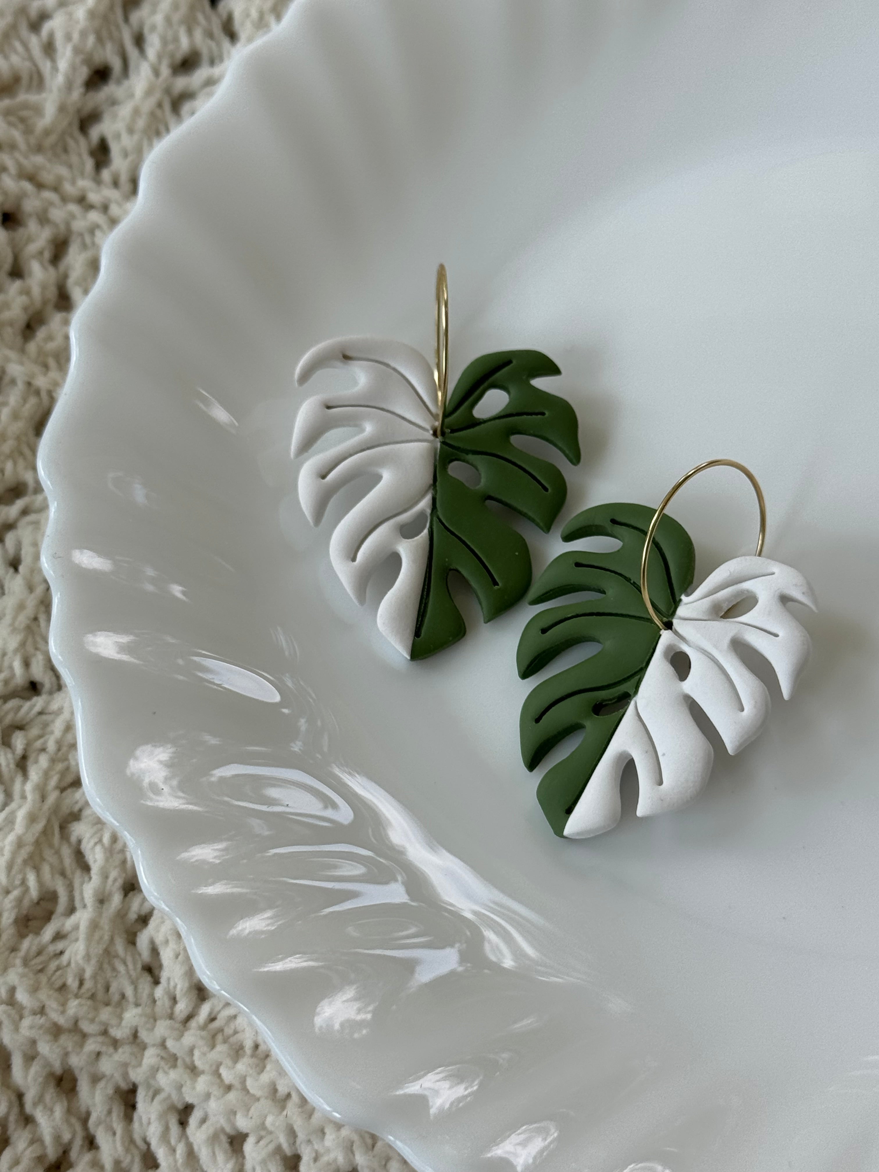 Handmade Variegated Monstera polymer clay leaf earrings with gold hardware.