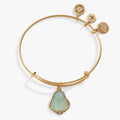 Alex and Ani Buddha Charm Bangle with etched Buddha charm and green jade-style stone on an expandable metal wire.