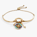 New Beginnings trio charm bracelet featuring a compass and blue gemstone charms.