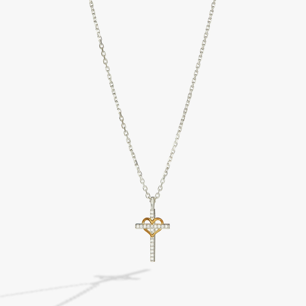 Crystal-encrusted silver cross and gold-plated heart pendant necklace on an adjustable sterling silver chain.