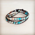 Double wrap bracelet featuring blue and earth-toned Imperial Jasper beads on a dark leather cord worn on a wrist