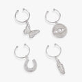 Set of 4 wine glass charms featuring butterfly, feather, evil eye, and horseshoe symbols on stemless wine glasses.