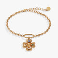 Gold-tone four-leaf clover bracelet with sapphire glass evil eye and clear crystal horseshoe charm