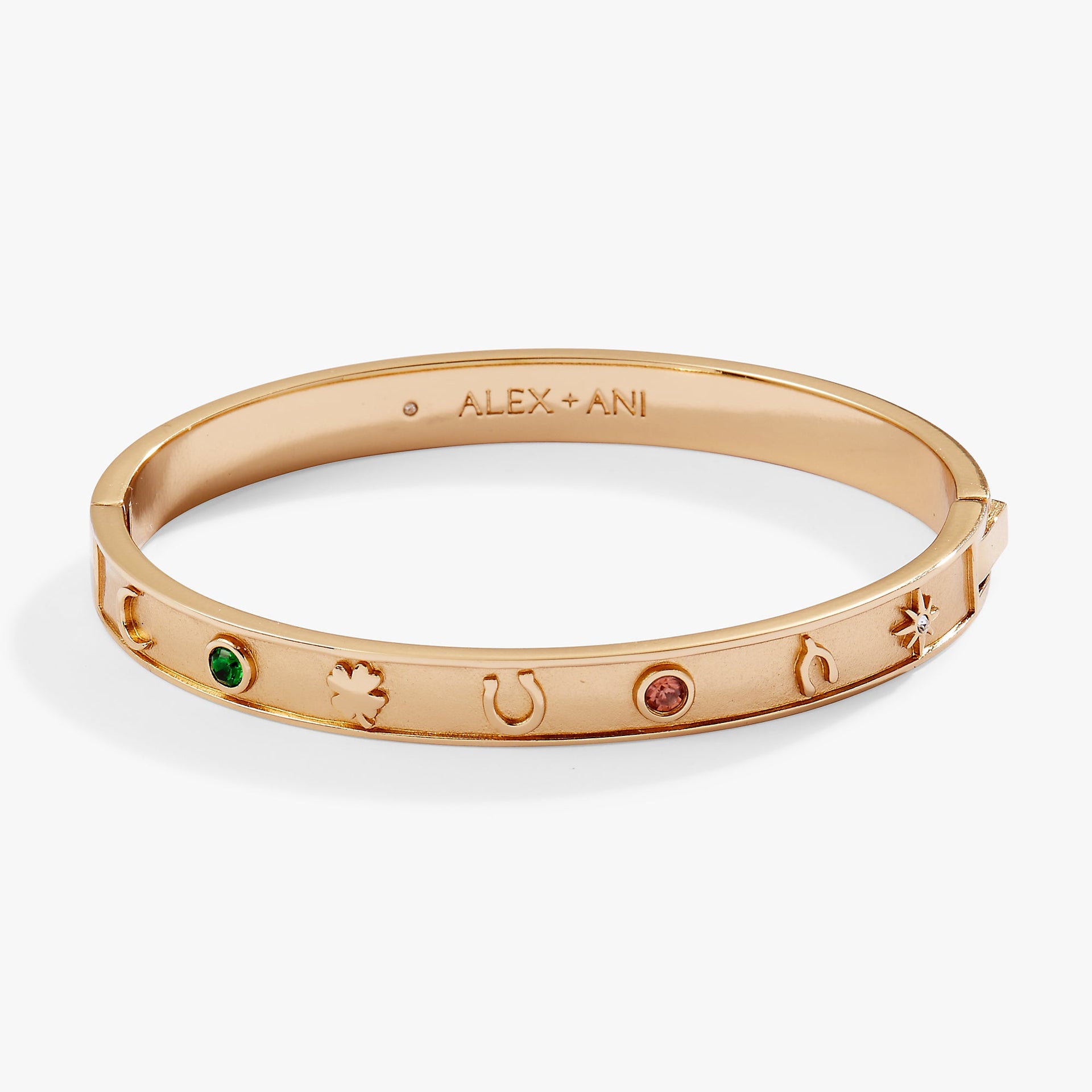 Gold tone hinge bangle bracelet with horseshoe, wishbone, and clover charms.