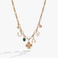 Emerald lucky charm necklace featuring a four-leaf clover, sapphire evil eye, and crystal symbols on an adjustable chain.