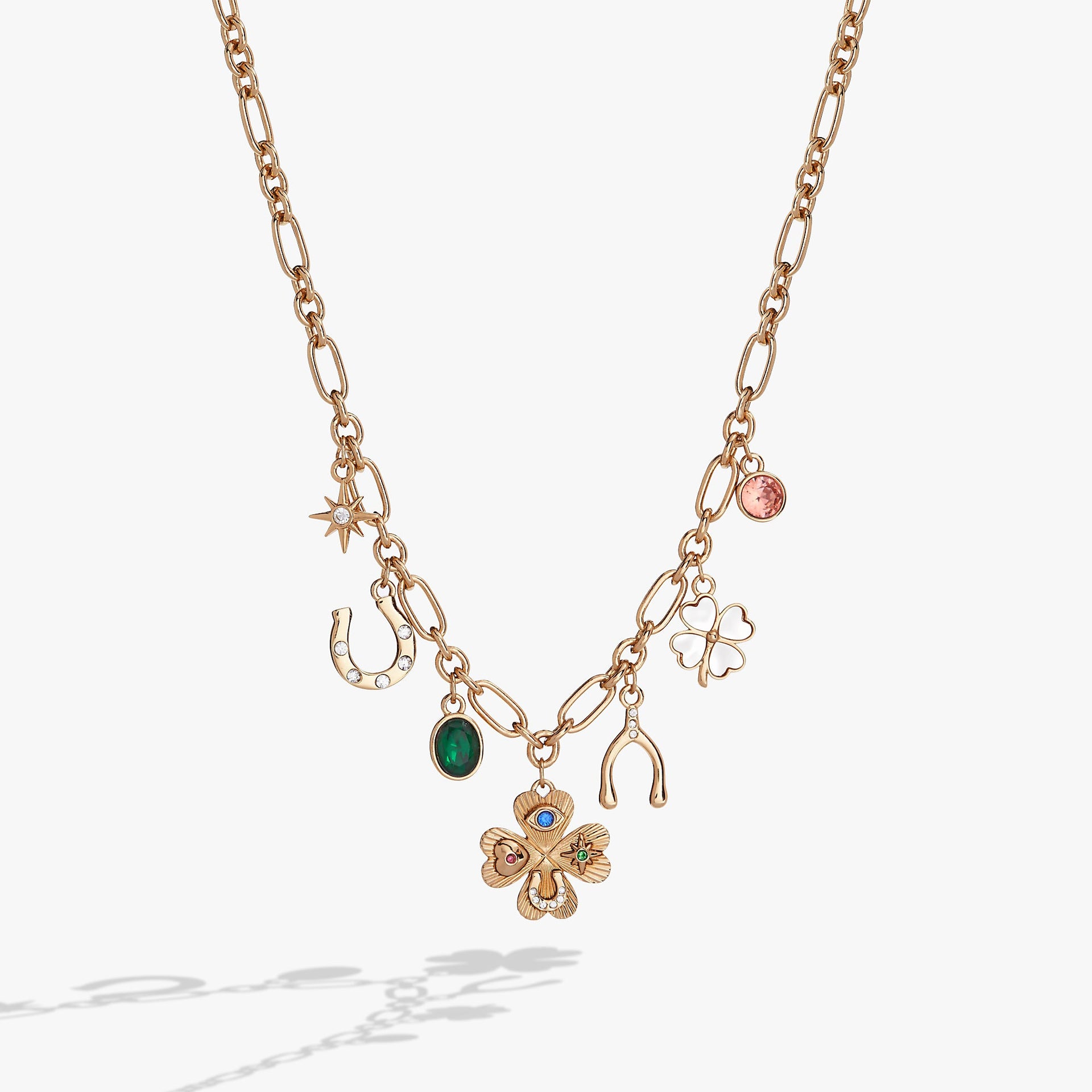 Emerald lucky charm necklace featuring a four-leaf clover, sapphire evil eye, and crystal symbols on an adjustable chain.