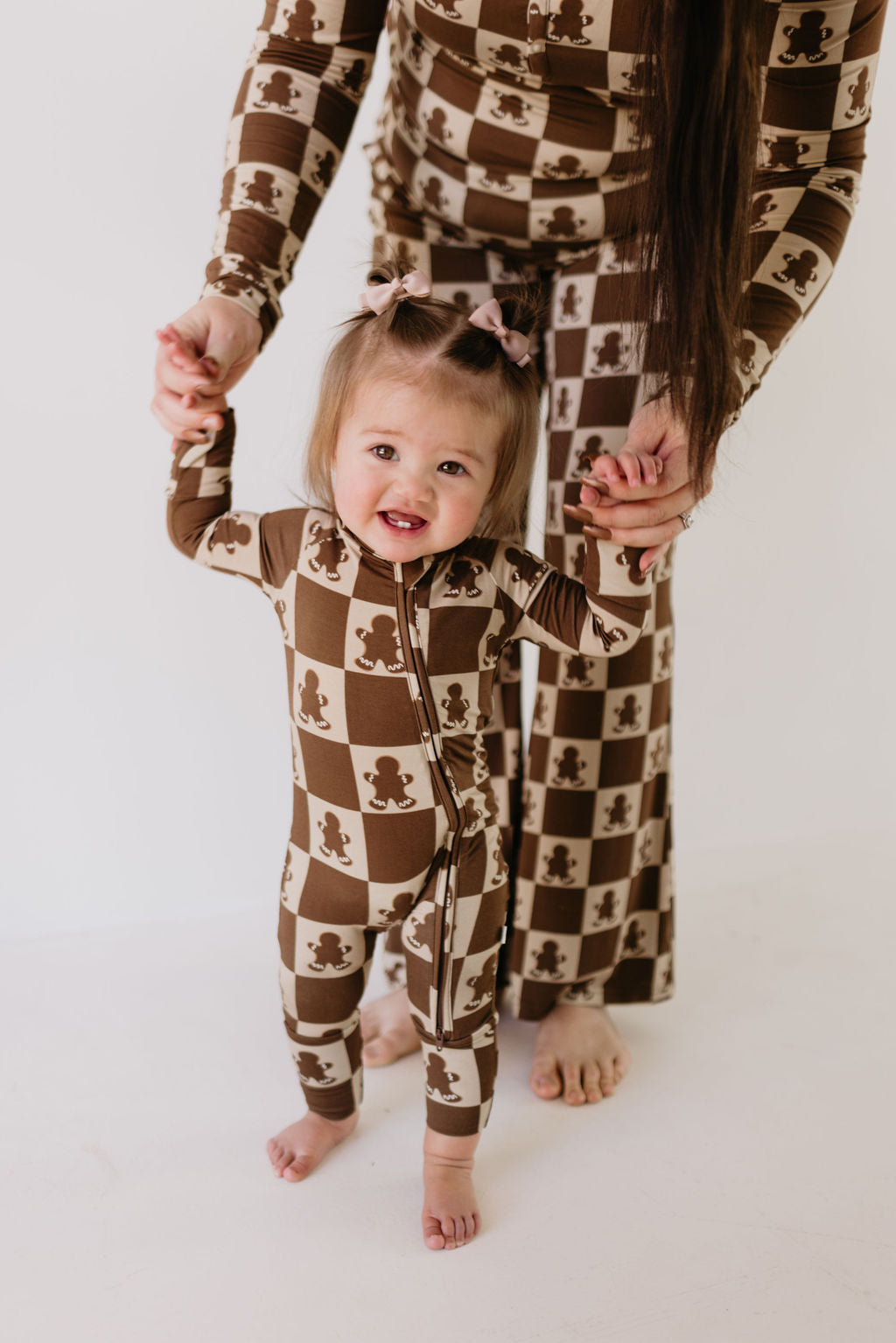 Child wearing Gingerbread Checkerboard bamboo zip pajamas in brown and cream checkerboard pattern.