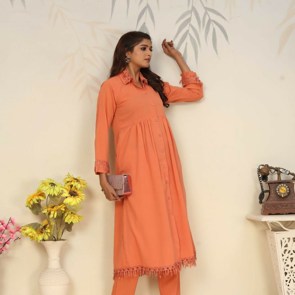 Women wearing a vibrant orange straight-fit Rinkal cotton kurti with side pockets and a collar V-neck.