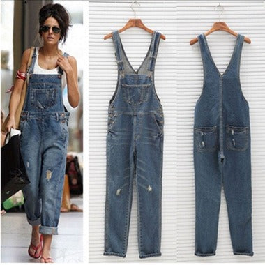 Women's distressed blue denim overalls with ripped details, a classic bib, and adjustable straps, styled casually.