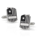 Close up of silver-tone military dog tag style cufflinks with flag design worn on a white dress shirt cuff.